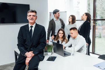 Canvas Print - Successful older businessman with his team working at modern office...