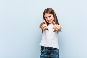 Wall Mural - Cute girl with thumbs ups, cheers about something, support and respect concept.