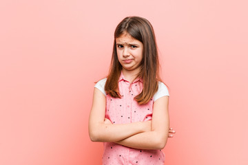 Wall Mural - Cute little girl unhappy looking in camera with sarcastic expression.