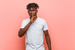 © Asier - Young african black man keeping a secret or asking for silence.