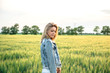 © AlexR - young attractive female on the field of wheat near a wind turbine generators, sunset orange light