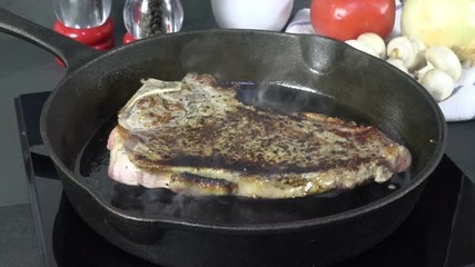 Sticker - Turning a rib steak in a cast iron skillet