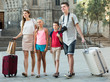 © JackF - Smiling family travelers with children walking with suitcases