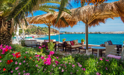 Tables with chairs in traditional Greek tavern near the sea