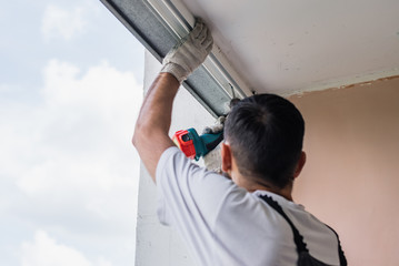 Process of man using screwdriver. Worker makes the installation of window