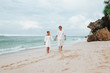 © Smeilov - girl and a man in white clothes walk on a white beach and hold hands
