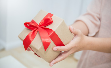 Close up hands giving gift box, girl surprise her mother with gift box. Boxing day holiday birthday christmas and mother’s day delivery online shipping concept