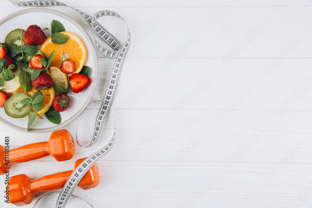 Diet plan, menu or program, tape measure, water, dumbbells and diet food of fresh fruits on white background, weight loss and detox concept, top view - obrazy, fototapety, plakaty 