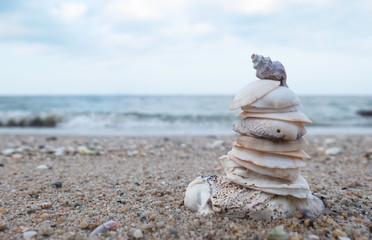 Stack of Sea shell at the beach with sea and blue sky on background Concept Zen, Spa . Blank space for text and images.