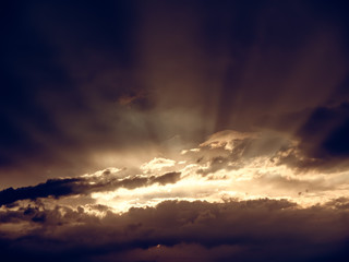 Wall Mural - sunset through the clouds. the lights of a sun