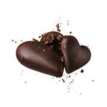 Two Chocolate Heart On A Beige Background. Hearts Collide And Break Up Into Crumbs. High-speed Shooting.