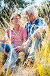 © Kzenon - Couple of senior woman and man sitting in a meadow in the grass