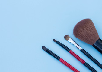 make up brushes blue background copy space