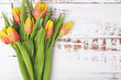 A bouquet of bright tulip at white wooden background with copy space