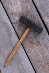 Wall Mural - Hammer on the boards, top view. Old steel hammer with wooden handle on the wooden planks background.