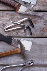 Wall Mural - Set of tools and instruments, top view. Old grungy tool set including hammer, pliers, knife and spatula on gray wooden boards background.