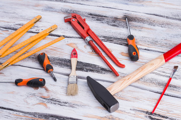 Wall Mural - Assorted construction tools on wooden background. Hammer, screwdrivers, paintbrush, folding ruler, adjustable wrench. Carpenter tools background.