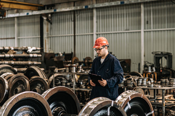 Supervisor at work in train factory.