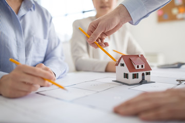 Canvas Print - architecture, construction business and people concept - close up of architects with blueprint discussing house project at office