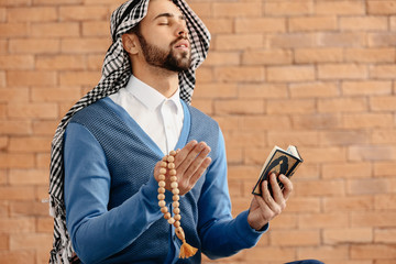 Wall Mural - Young Muslim man praying indoors