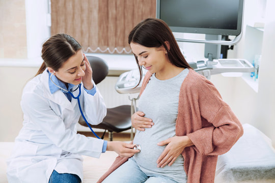 female gynecologist working with pregnant woman in clinic