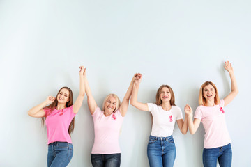 Sticker - Happy women of different ages with pink ribbons on light background. Breast cancer concept