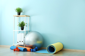 Wall Mural - Set of sports equipment with fitness ball near wall