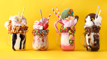 Different Delicious Freak Shakes On Color Background