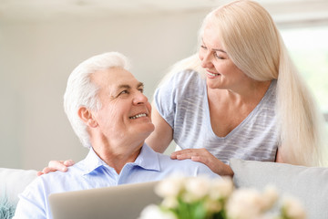 Sticker - Portrait of happy mature couple with laptop at home