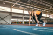 © Andriy Bezuglov - Sportive blonde woman training at indoor stadium