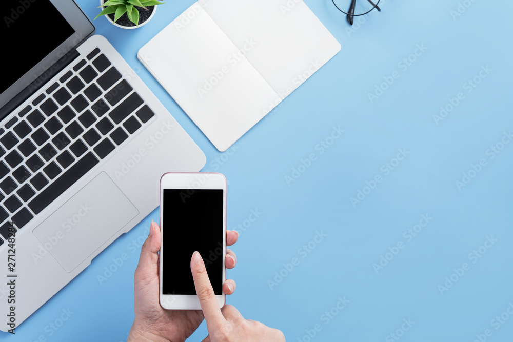 Woman holding smartphone with a minimal blue desk, concept of online shopping, internet payment, e-commerce, copy space, flat lay, top view, mock up - obrazy, fototapety, plakaty 