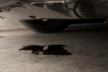 Oil leak or drop from engine of car on concrete floor , check and maintenance auto service