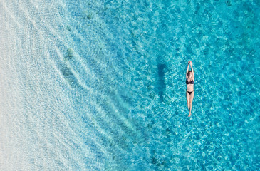 Wall Mural - aerial view of a girl on ocean on bali, indonesia. vacation and adventure. turquoise water. top view