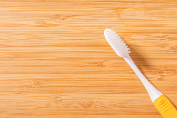 Toothbrush on brown wooden table.