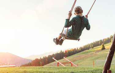 Little Boy swinging on the mountain kids park playground