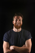 © Curto - portrait of a man smiling and with arms crossed and black background
