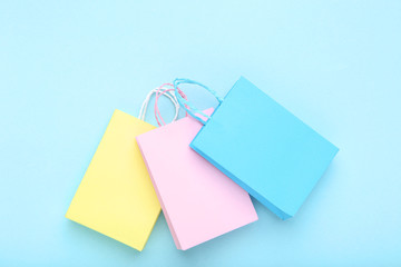 Canvas Print - Small paper shopping bags on blue background