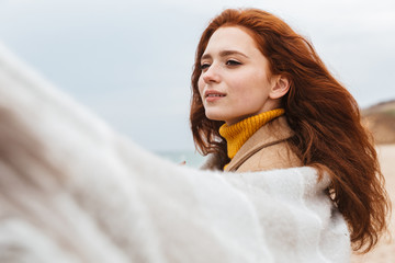 Beautiful young redheaded woman wearing coat