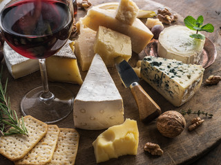 Wall Mural - Cheese platter with organic cheeses, fruits, nuts and wine. Tasty cheese starter.