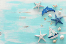 Vacation And Summer Concept With Vintage Boat, Starfish And Seashells Over Pastel Blue Wooden Background. Top View Flat Lay