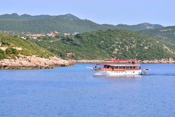 Boat tour. Sightseeing ship with tourists sails by the sea.