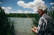 © Daniel - Senior man fishing by a lake