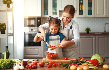 Poster - happy family mother with child girl preparing vegetable salad .