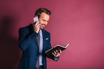 Wall Mural - Man with mobile phone and a notebook