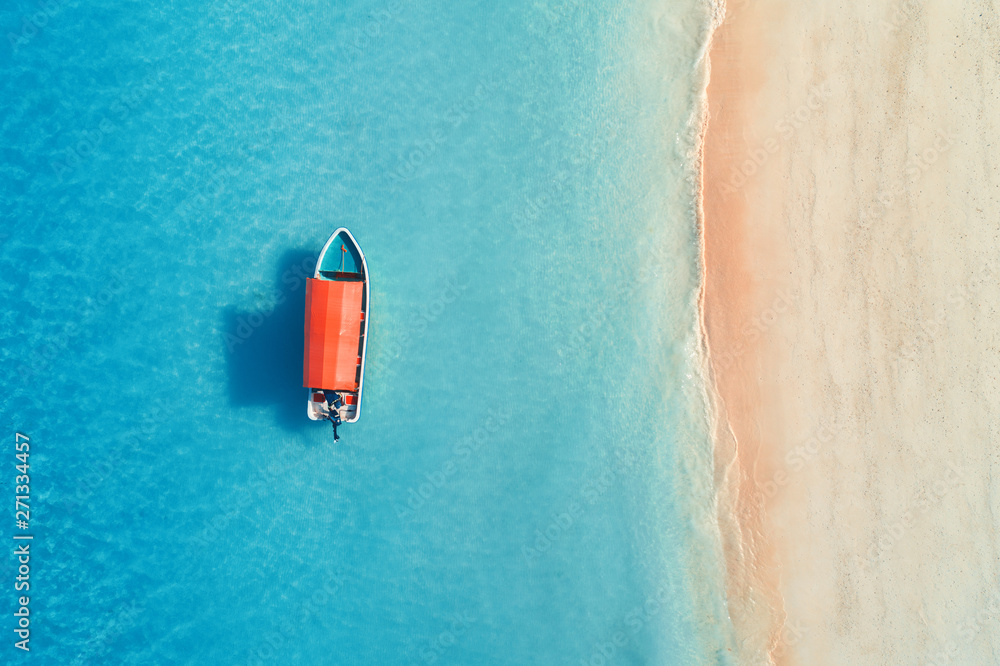 Aerial view of the fishing boat in clear blue water at sunny day in ...