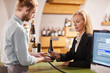 © Seventyfour - Portrait of mature woman buying wine using NFC payment at winery shop, copy space