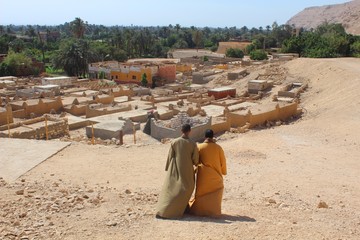 two men descending hill heading to the village