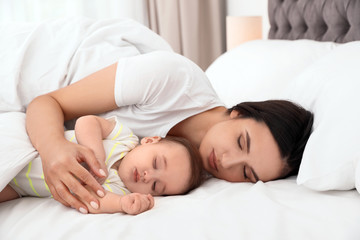 Sticker - Mother and her cute baby sleeping on bed indoors