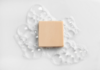 Soap bar and foam on white background, top view. Mockup for design