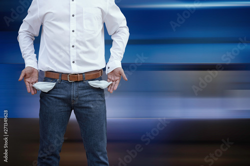 Fotografía Man showing his empty pockets on abstract modern blue background.